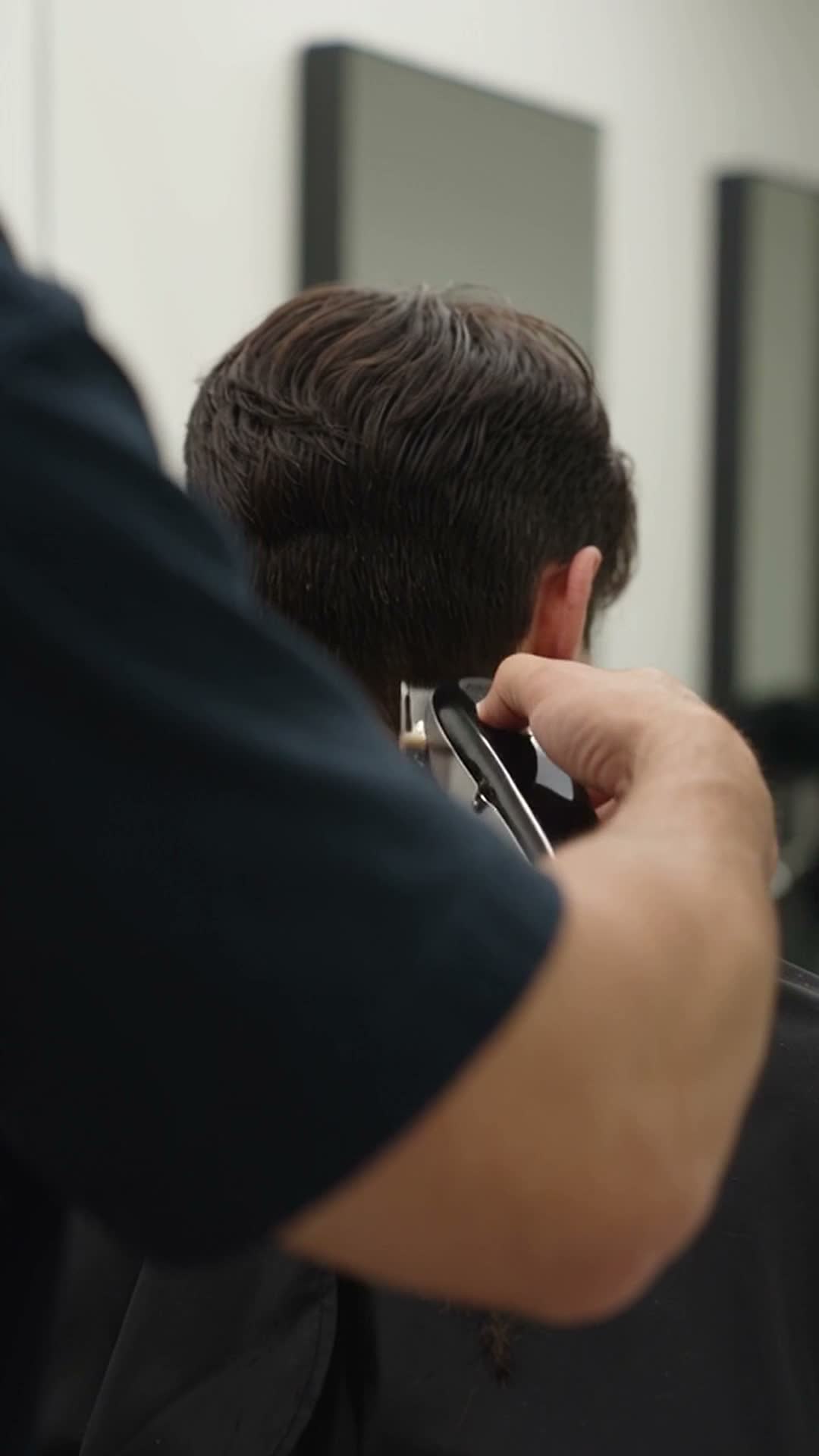 Barber giving a client a haircut in a shop
